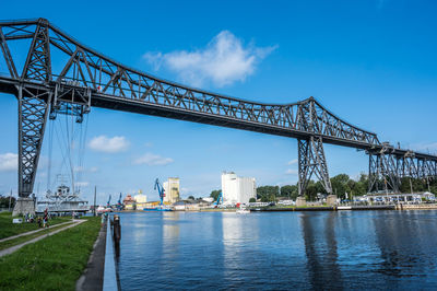 Bridge over river against clear blue sky