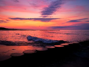 Scenic view of sea against romantic sky at sunset