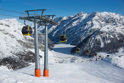 Overhead cable cars on snow covered field 