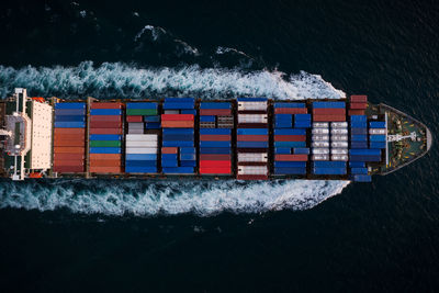 Container ship sailing fast in sea top view at night process, service and international transport 