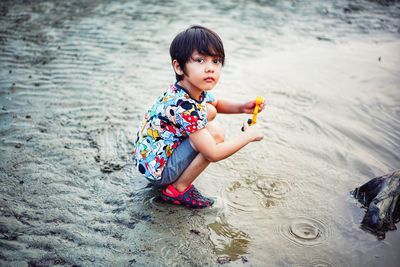 High angle view of boy playing with toy on beach