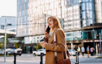 Focused business woman talking on smartphone at city background