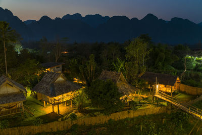High angle view of trees and buildings against sky at night