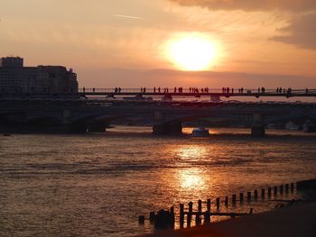 Bridge over sea against sky during sunset