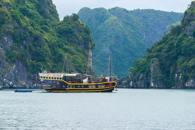 Boat sailing on river by mountain