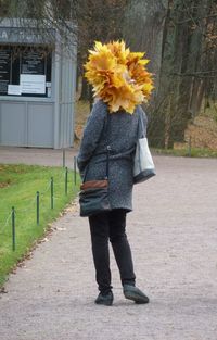 Full length of woman standing by flowering plants