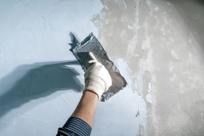 Low section of woman standing against wall