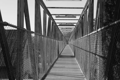 Empty footbridge against sky