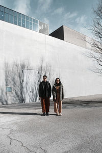 Rear view of man and woman walking on street in city