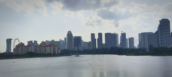 Buildings in city against cloudy sky