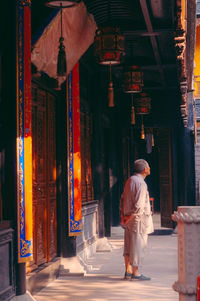 Full length rear view of man walking by building