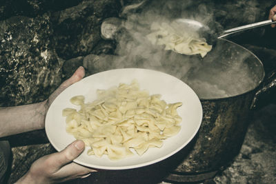 Close-up of hand holding ice cream in bowl