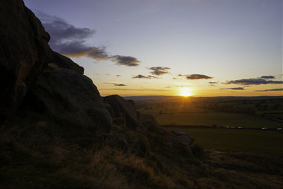 Scenic view of rocks against sky during sunset