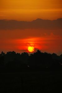 Scenic view of silhouette landscape against orange sky