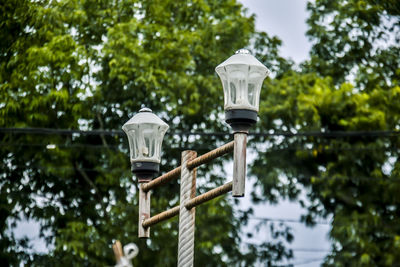 Low angle view of street light against trees