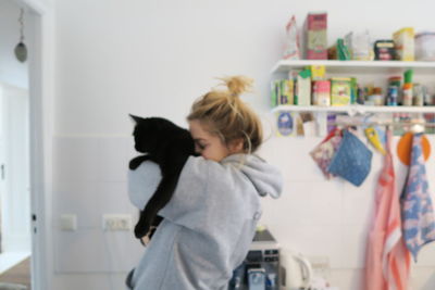 Rear view of woman and cat at home