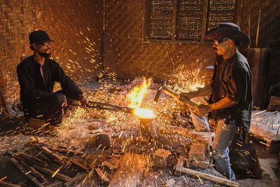 Side view of man and woman sitting on fire