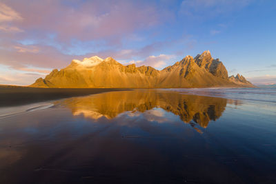 Scenic view of lake by mountains against sky