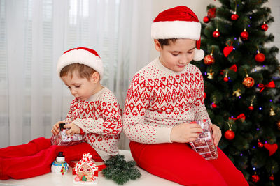 Surprised children unpack christmas gift boxes. smiling boys