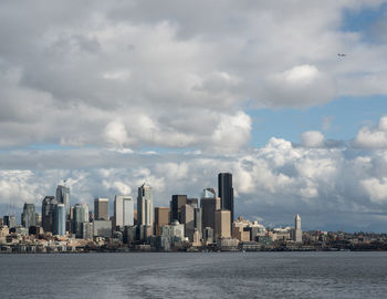 Sea by cityscape against sky