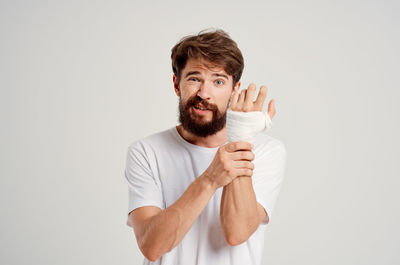 Portrait of man wearing bandage against white background