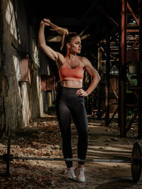 Full length of woman looking away while standing in abandoned building