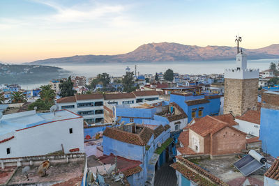 High angle view of townscape by sea against sky