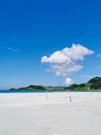 Scenic view of beach against blue sky