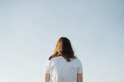 Rear view of woman standing against clear sky