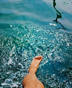 Low section of person splashing water in lake