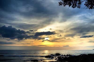 Scenic view of sea against cloudy sky during sunset