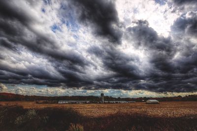 Scenic view of field against cloudy sky