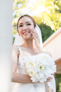 Portrait of a smiling young woman against white wall