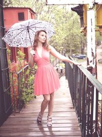 Full length of woman standing on railing