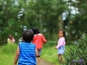 Children playing with bubbles in park