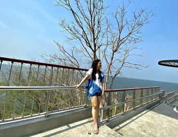 Full length of woman on footbridge against sky