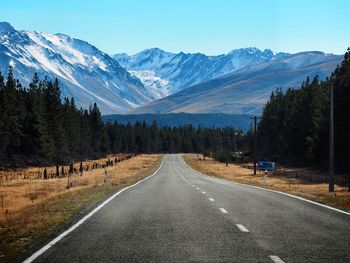 Road by mountains against sky