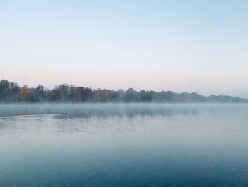 Scenic view of lake against sky at foggy weather