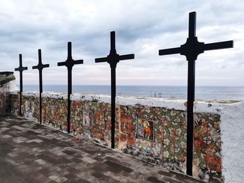 Cross by sea against sky