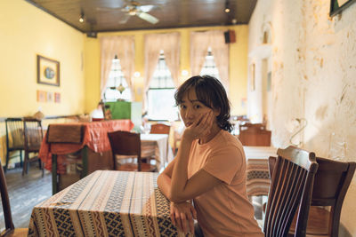 Side view of young woman sitting in a cafe