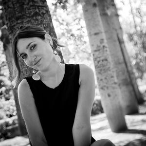 Portrait of woman against tree trunk