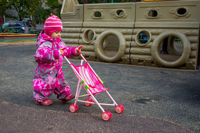 Cute kid walking with baby stroller