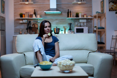 Portrait of young woman sitting on sofa