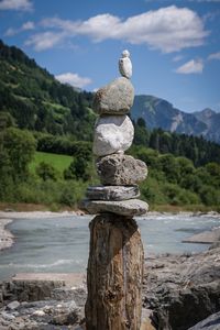 Stack of wooden post against trees on mountain