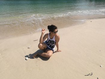 High angle view of young woman sitting on beach