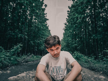 Portrait of young man looking away in forest