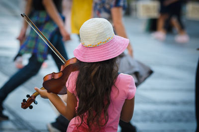 Rear view of a girl playing violing