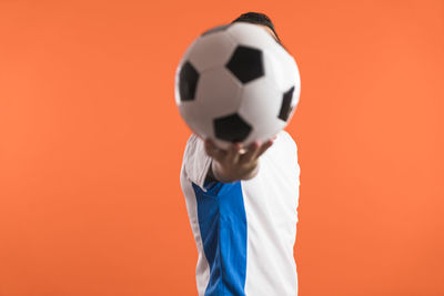 Close-up of soccer ball against yellow background