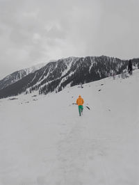 Person skiing on snowcapped mountain against sky