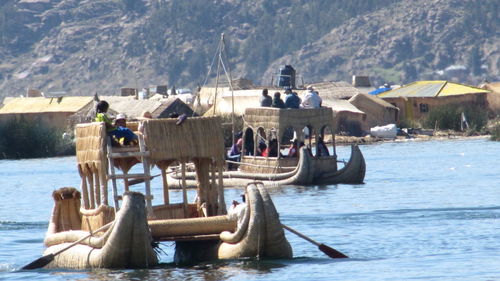 Group of people on boat against mountains